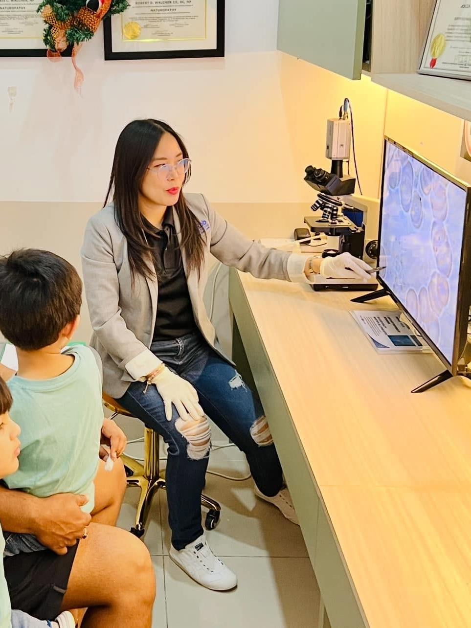 Practitioner explaining live blood analysis results to a family
